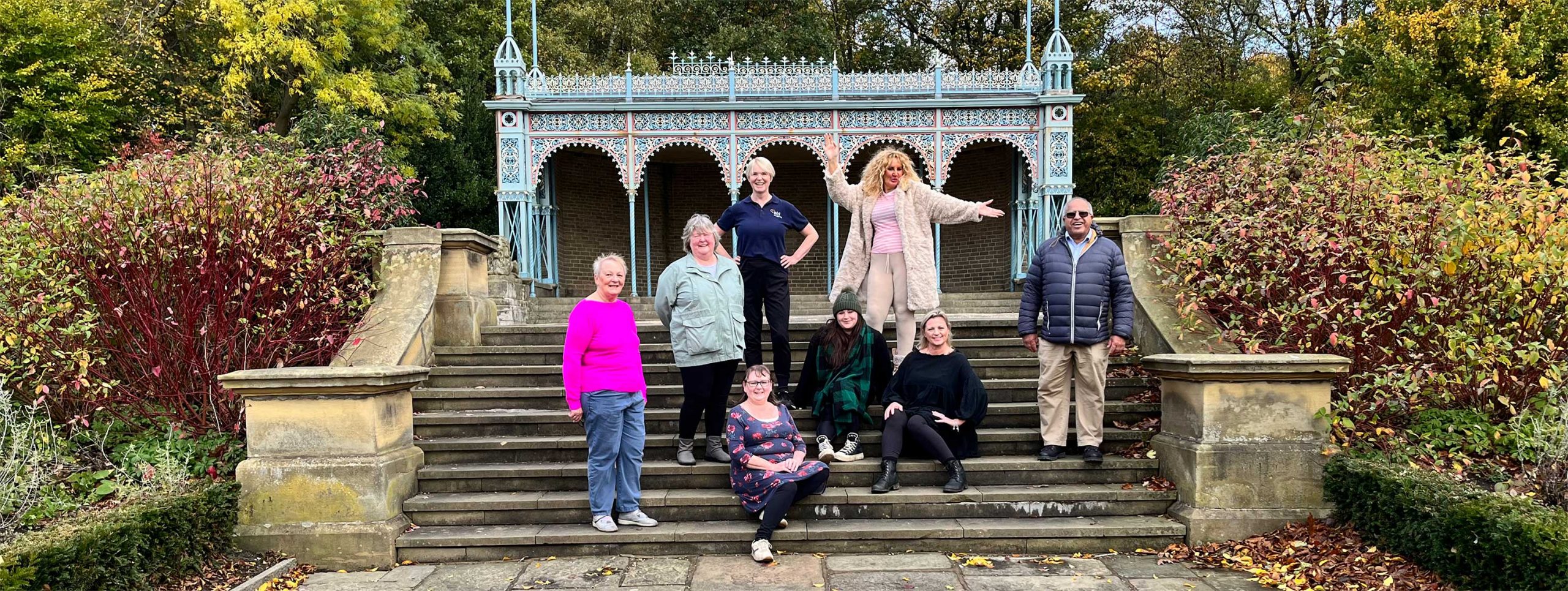 Members posing for photo on steps in local park